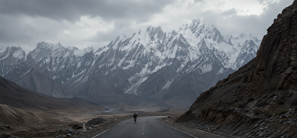 雪山山谷中的公路与远处骑行者
